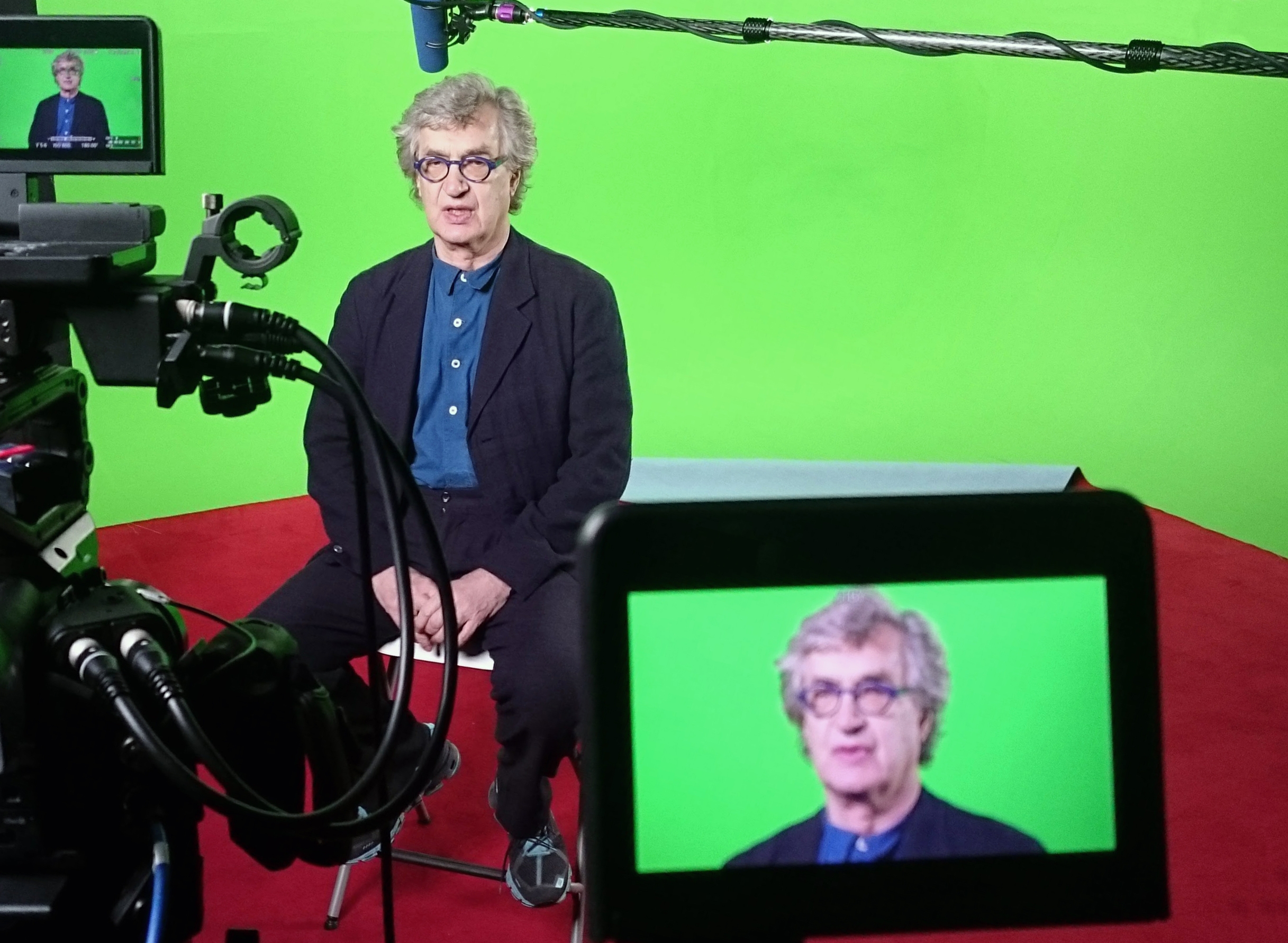 person being interviewed in front of a greenscreen backdrop