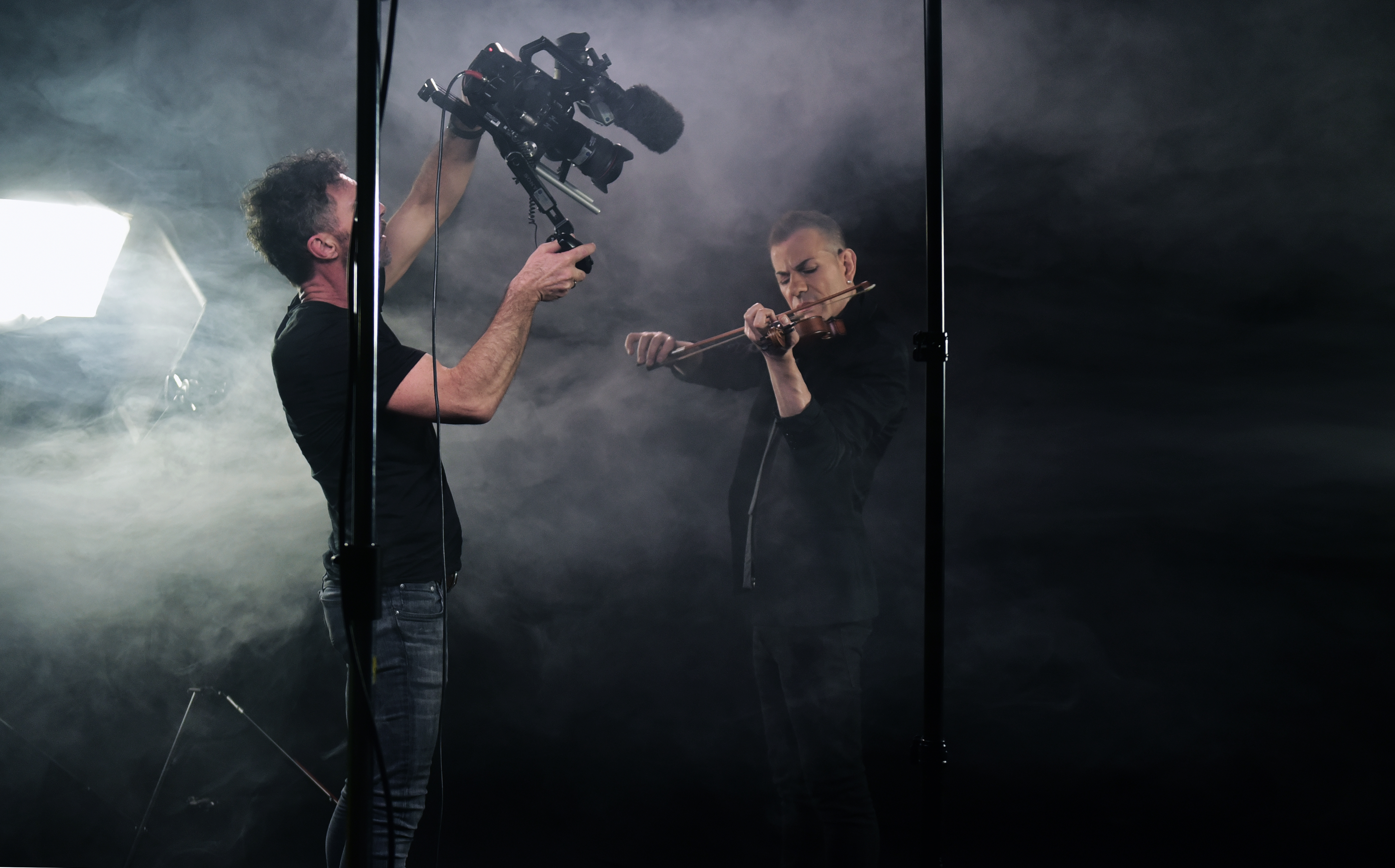 violin performer being recorded by a cameraman on a studio